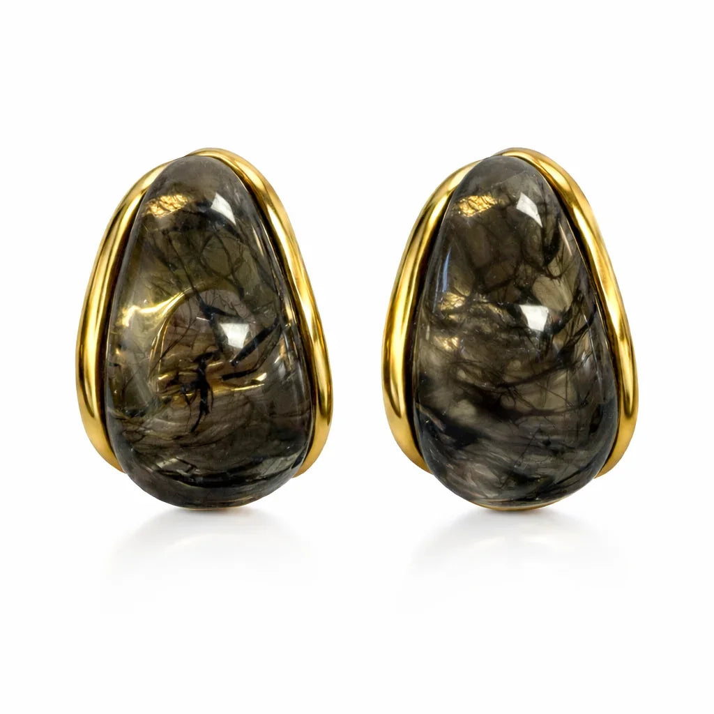 Pair of earrings with gold rims and dark stones on a white background